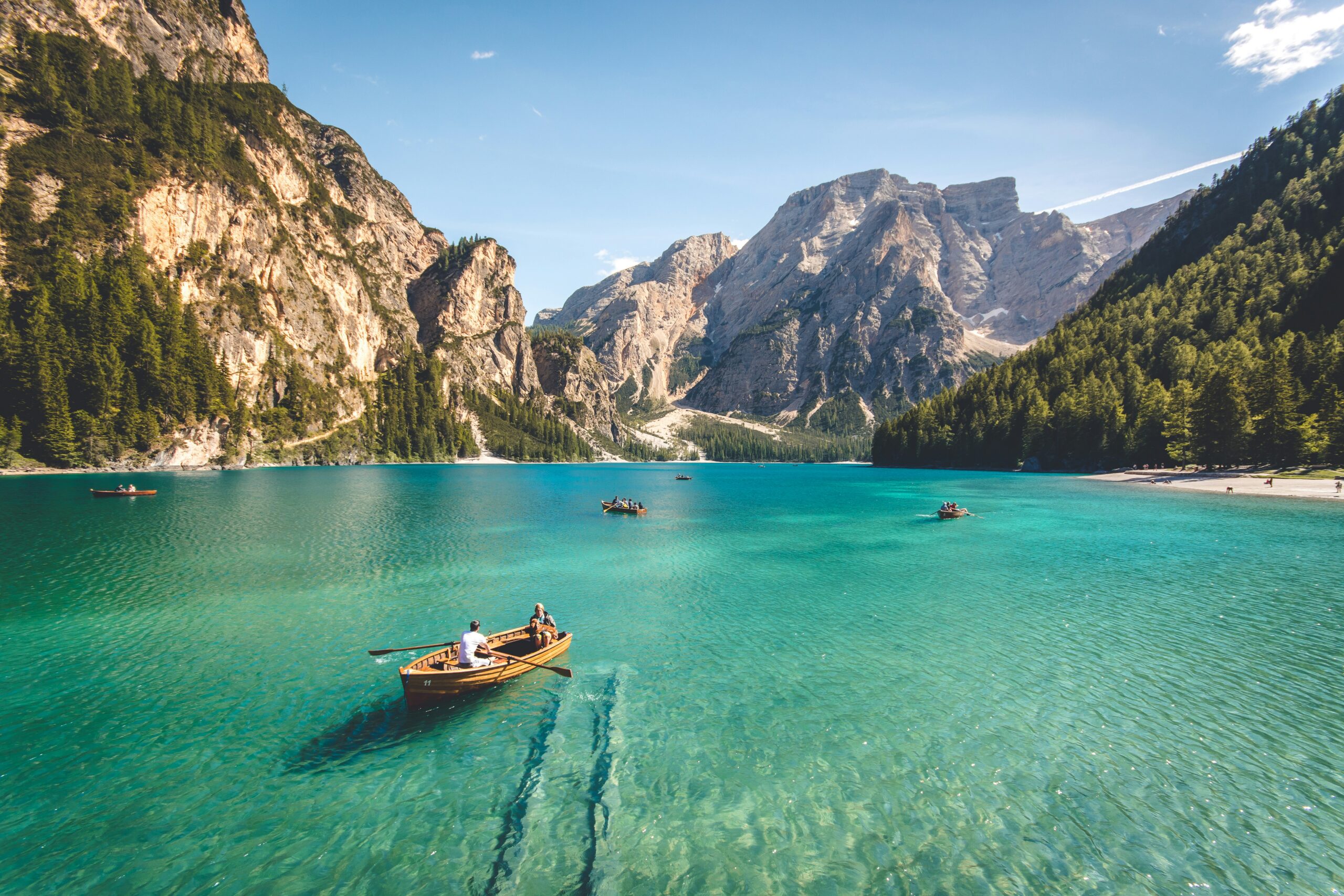 Three brown wooden boat on blue lake water taken at daytime