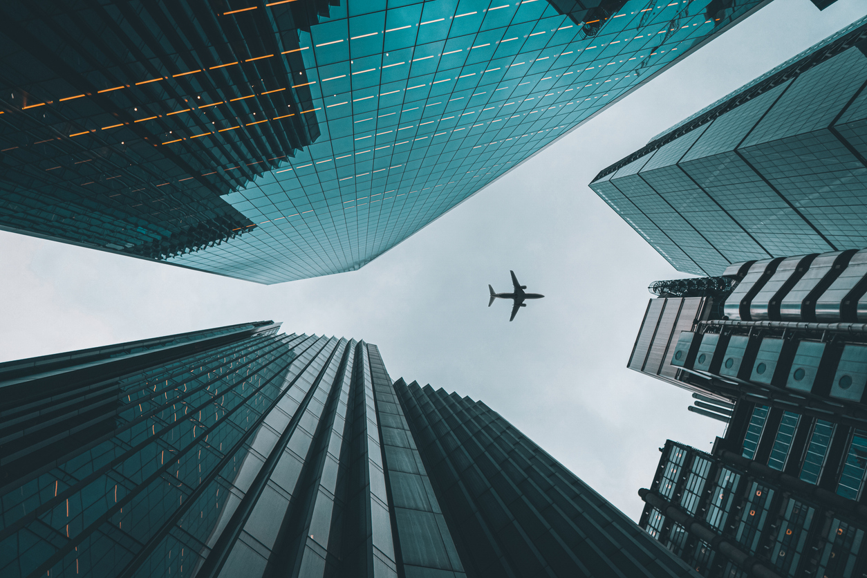 Plane flying over buildings in London Liverpool street.
